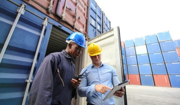Engineer or supervisor checking and control loading Containers box from Cargo at harbor.Foreman control Industrial Container Cargo freight ship at industry.Transportation and logistic concept.